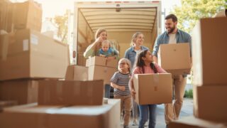 引っ越し作業をスムーズに行う家族　写真風、段ボールやトラック、協力して荷物を運ぶ様子、明るい配色で見やすい構図